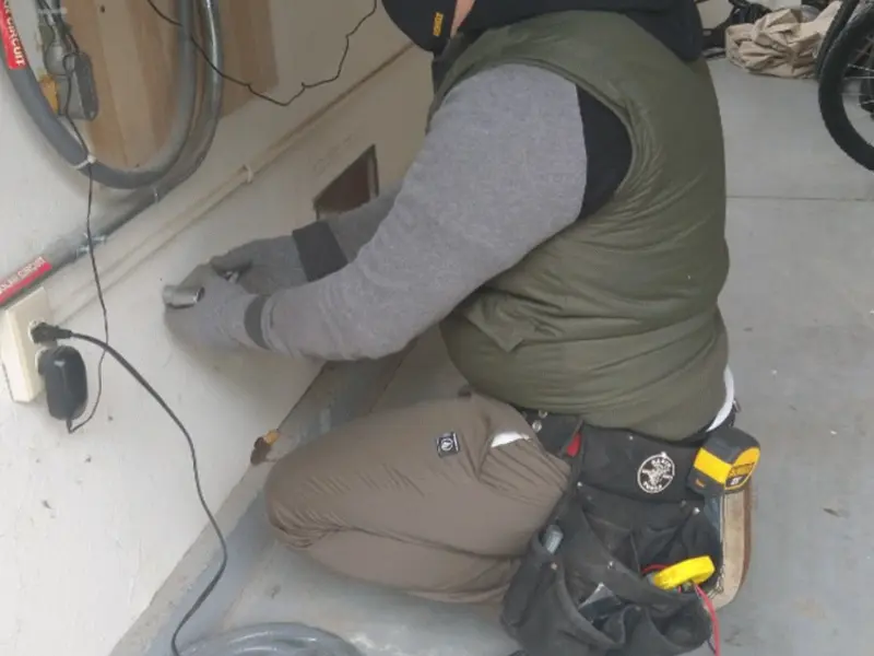 Electrician performing outlet wiring in a Muscatine garage